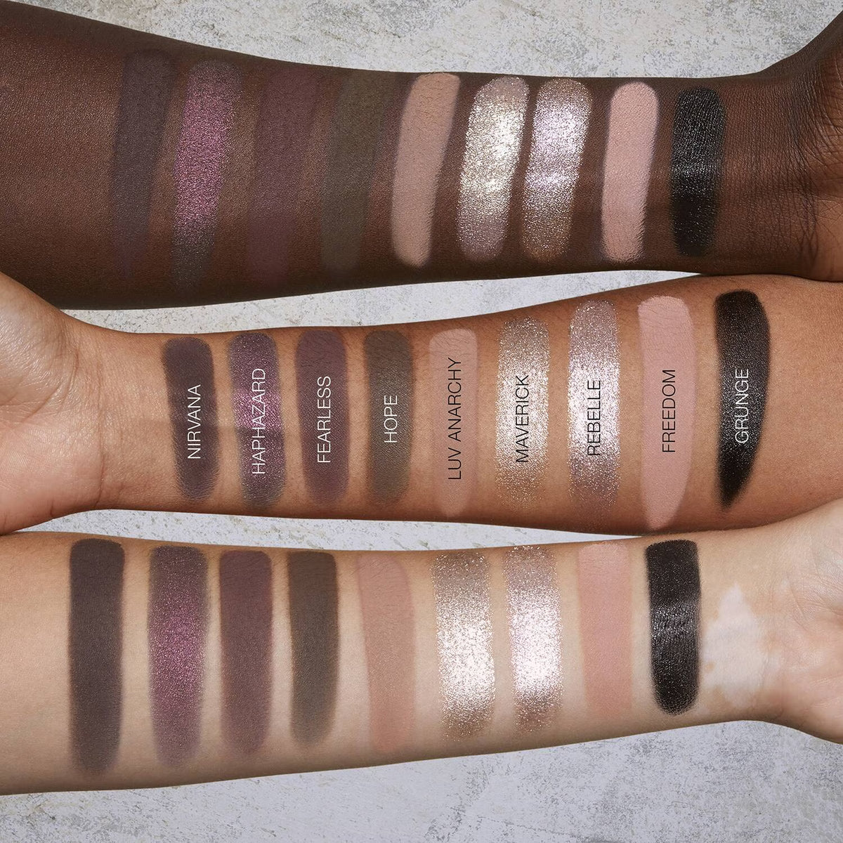 Swatches of eyeshadow on a person's arm with labeled colors.