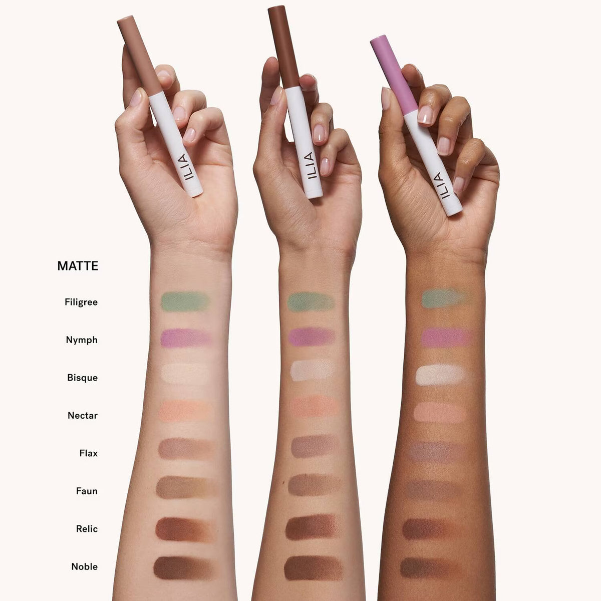 Three hands holding ILIA lip products with color swatches on arms