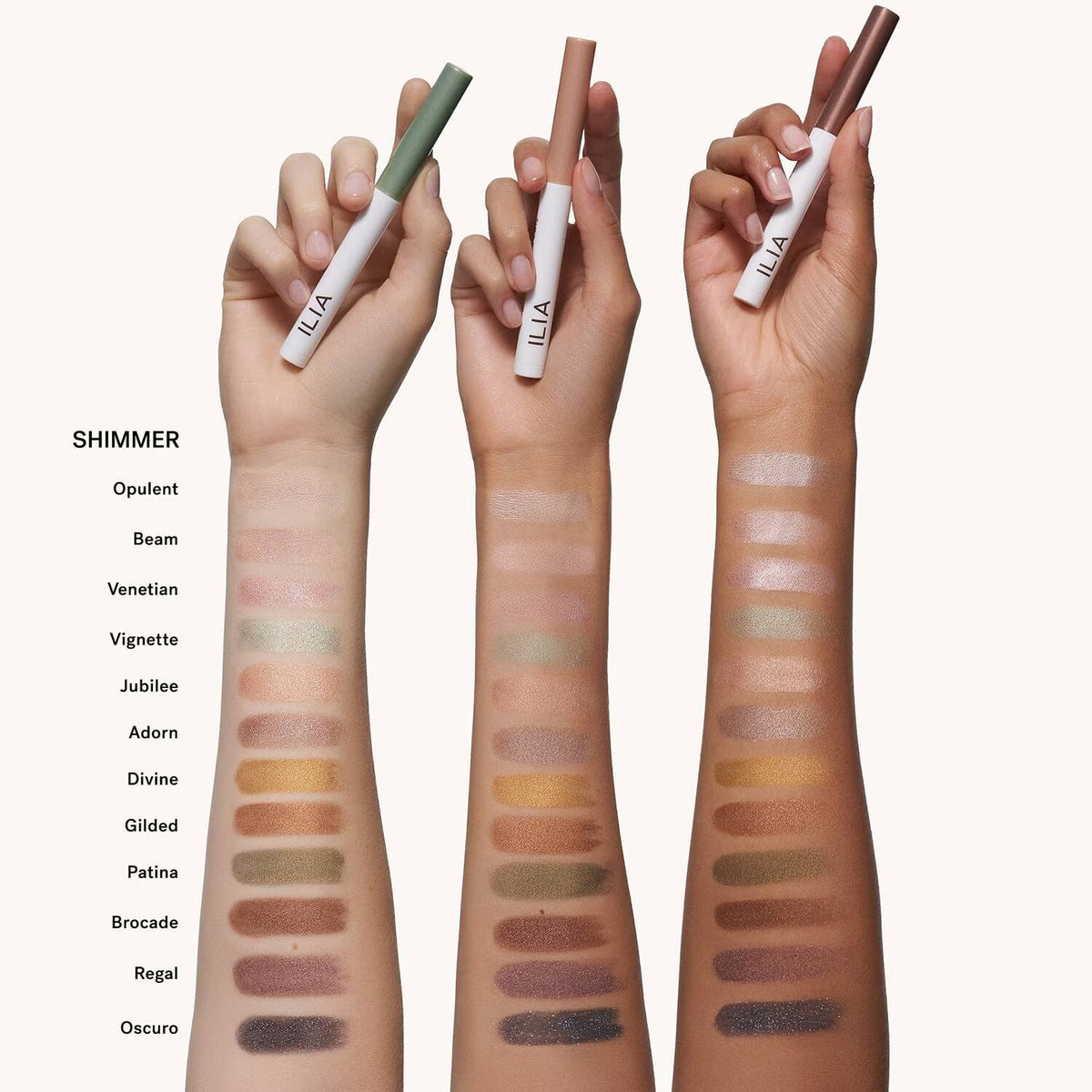 Hands holding ILIA makeup products with color swatches on a white background
