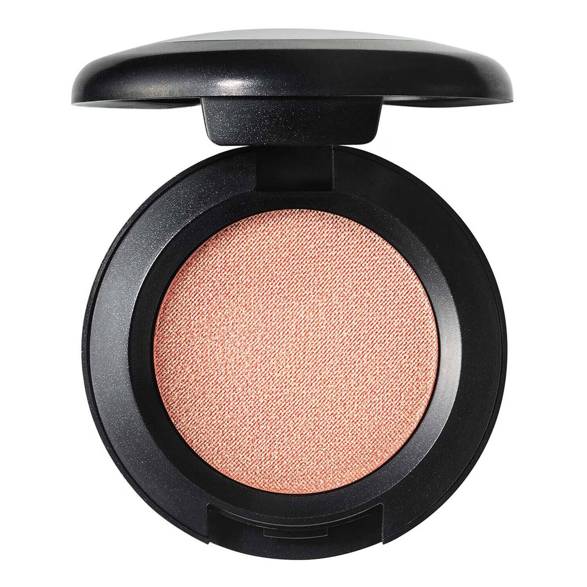 An open round makeup compact with a black casing, showing a textured, shimmering peach-pink pressed powder, likely a blush or eyeshadow, on a solid white background.