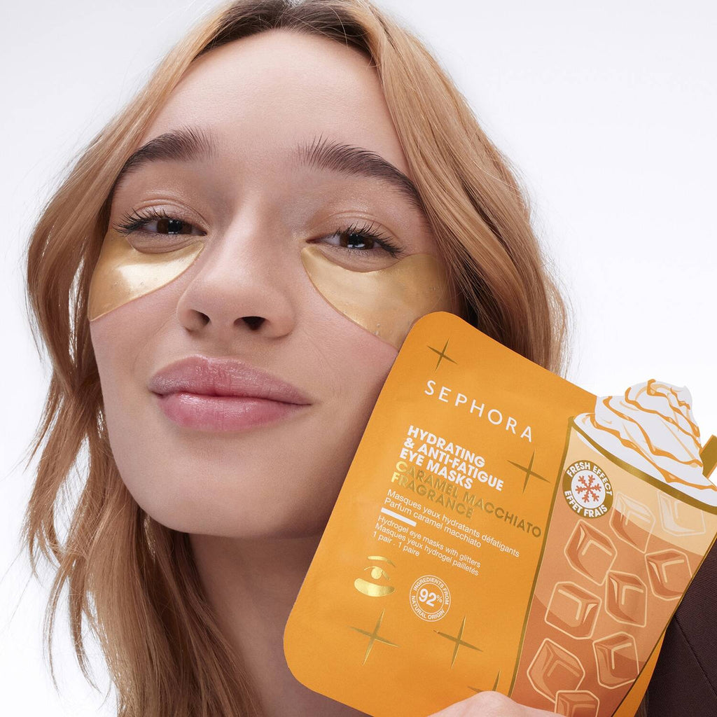 Woman wearing gold eye masks with a Sephora product packaging in the foreground