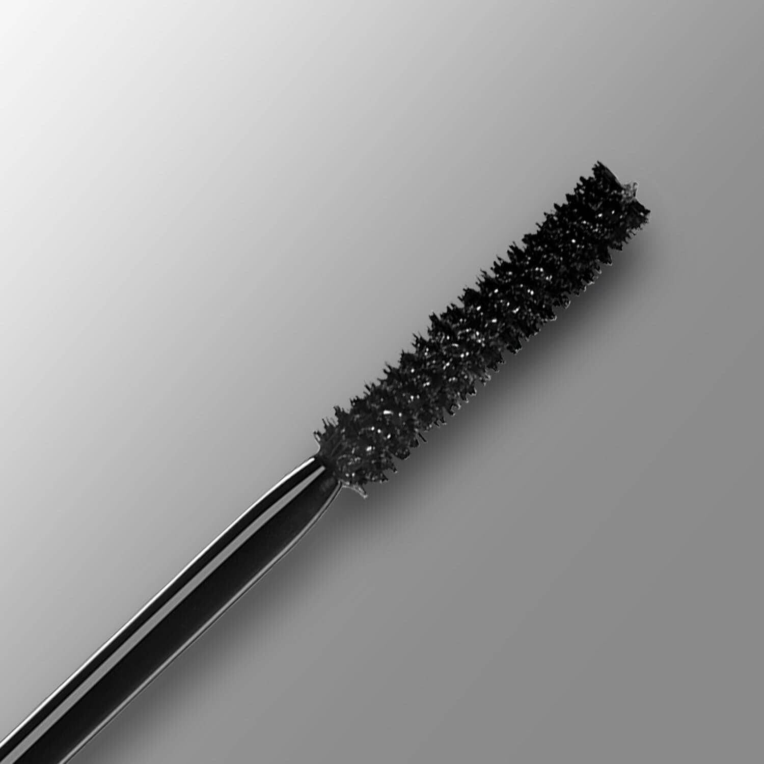 Black mascara wand on a gray background