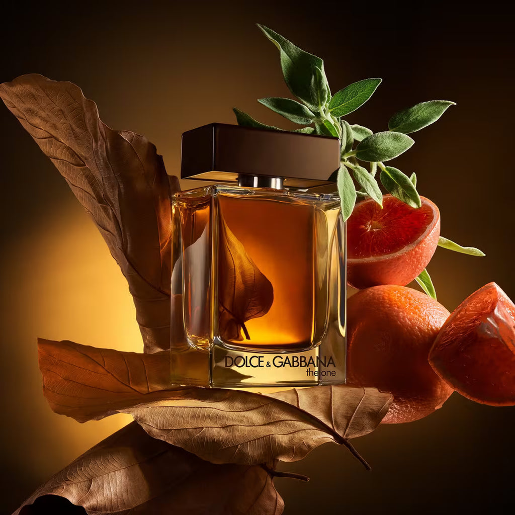Dolce & Gabbana perfume bottle with oranges and leaves on a reflective surface