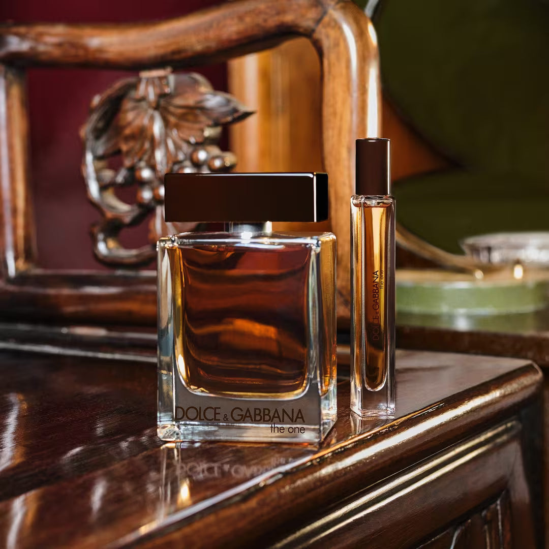 Two Dolce & Gabbana perfume bottles on a wooden surface with a decorative background.