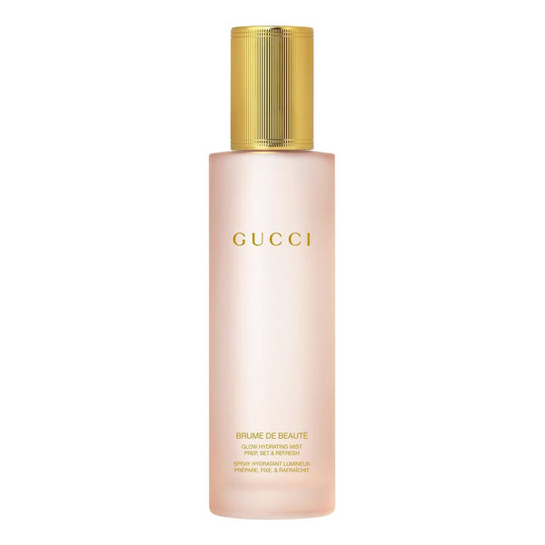 Gucci Brume de Beauté Glow Revitalizing Mist in a frosted pale pink bottle with a ribbed gold cap, centered on a white background.