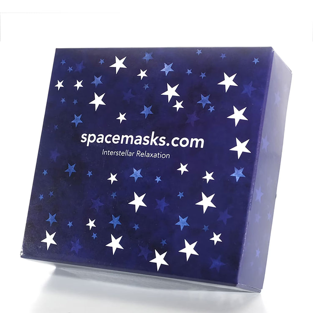 A square product box with a dark blue space-themed design featuring white and light blue stars, with the text 'spacemasks.com' and 'Interstellar Relaxation' printed on the front, set against a plain white background.