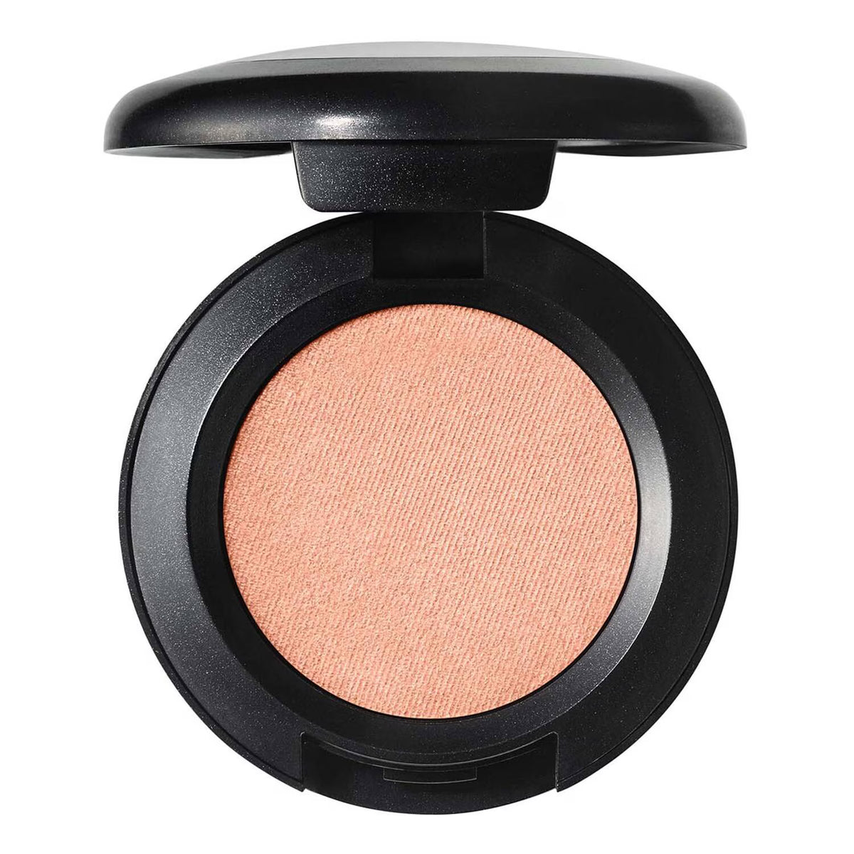 An open round makeup compact showing a peachy pink pressed powder, with a black casing and matching black lid, isolated on a white background.