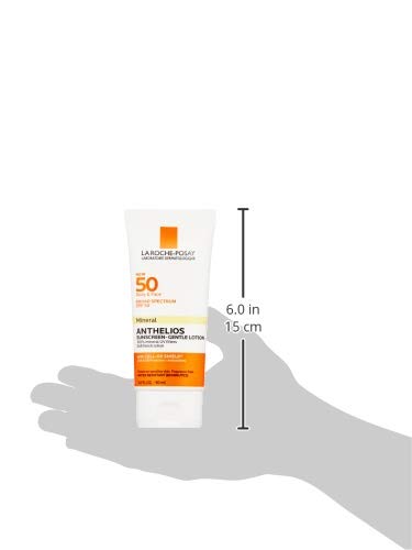 L'Oréal Paris Anthelios sun cream tube held in a hand with size measurement on a white background