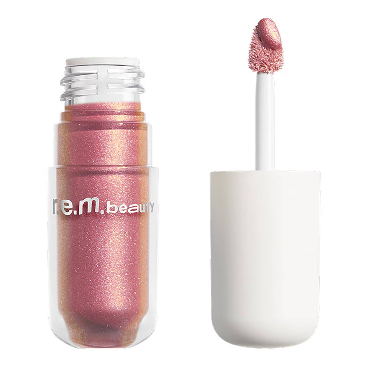 A clear cosmetic bottle filled with shimmering metallic pink-rose liquid makeup, shown next to its white applicator wand on a plain white background. The bottle has the brand name 're.