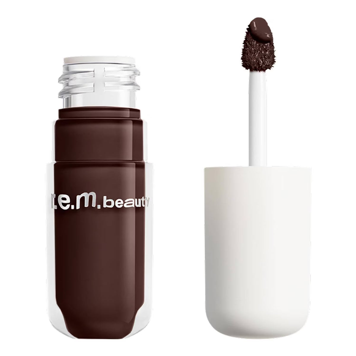 A clear cosmetic bottle filled with deep brown liquid makeup, shown next to its white cap and applicator wand on a plain white background. The bottle has white text reading 'm.