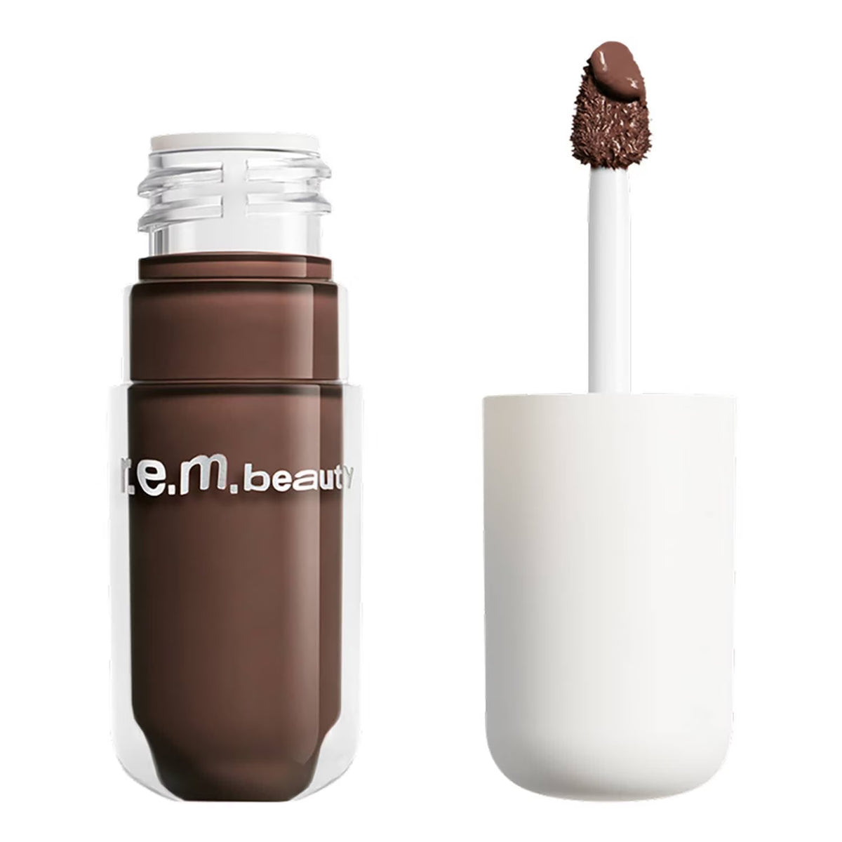 A liquid makeup product in a clear bottle with a white cap, shown next to its applicator wand coated with a dark brown cream product. The bottle has 'n.
