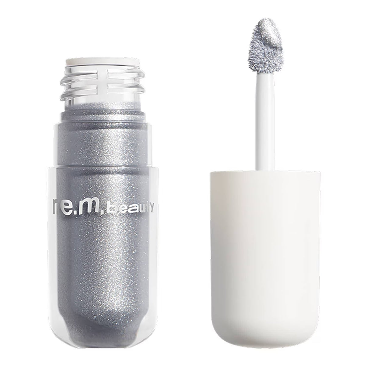 A clear cosmetic bottle filled with shimmering silver glitter makeup, shown next to its white applicator wand on a clean white background. The brand name 're.