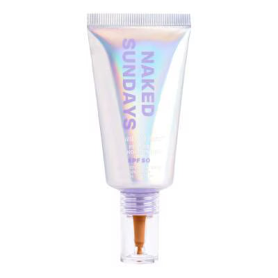 A squeeze tube of NAKED SUNDAYS SPF 50 sunscreen with an iridescent holographic finish and a clear cap showing a light beige cream inside, on a white background.