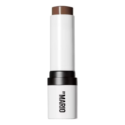 Makeup stick with brown top and white body on a white background, featuring 'By Mario' branding.