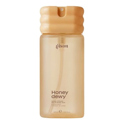 A 100ml bottle of Gison Honey Dewy hair & body mist, featuring a translucent warm beige body and a ribbed golden-ochre cap, set against a plain white background.