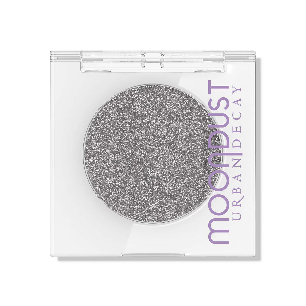 A single-pan eyeshadow compact by Moon Dust Urban Decay, featuring a sparkling silver glitter shadow in a clear plastic case with a white base and purple branding.