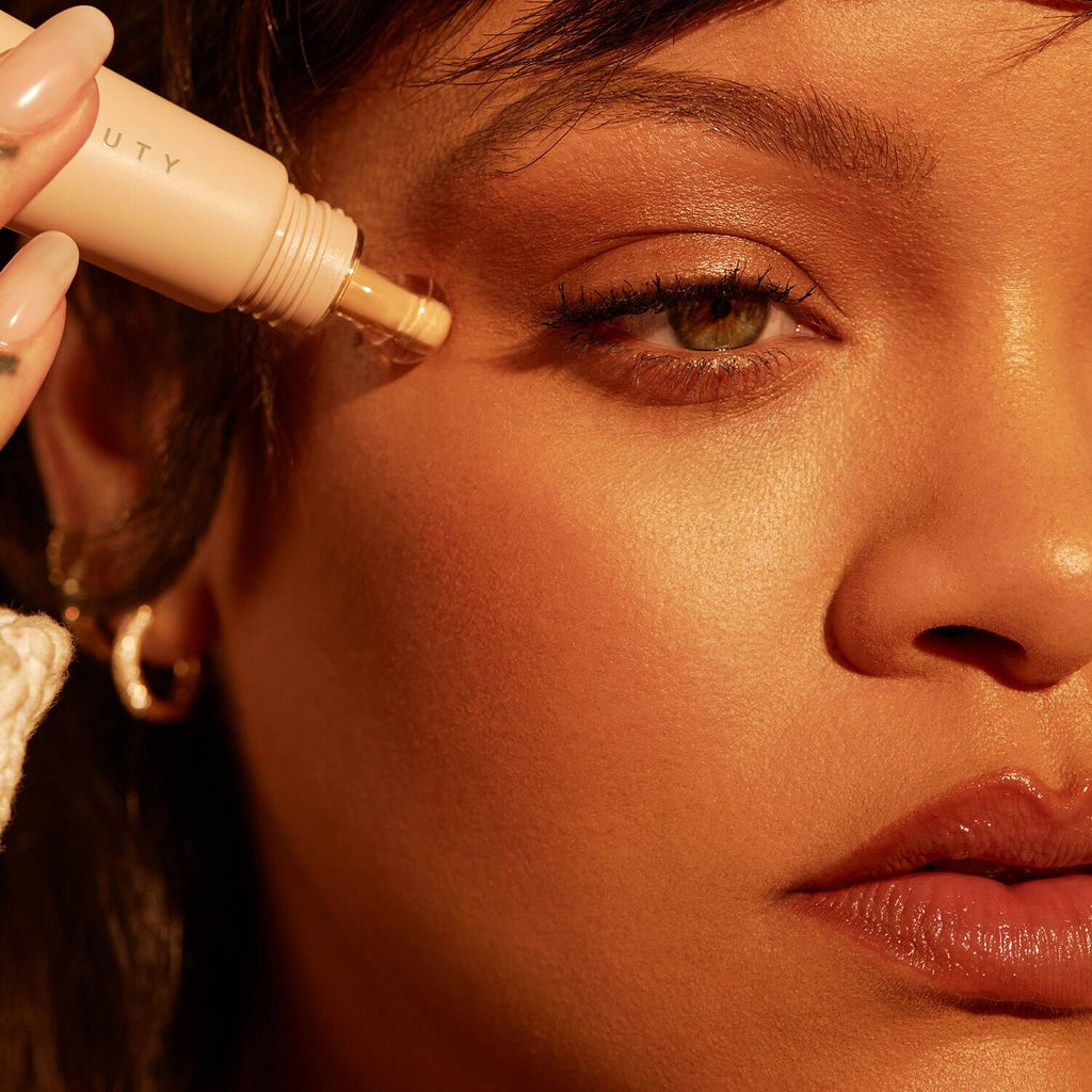 Close-up of a woman applying makeup with a beauty product.