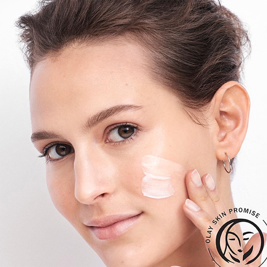 Woman applying cream to her face with Olay Skin Promise logo.