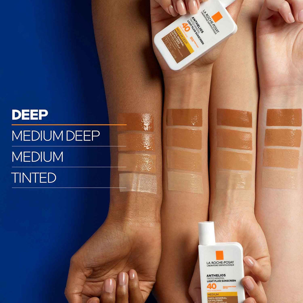 Hands holding sunscreen bottles with color swatches on skin tones.
