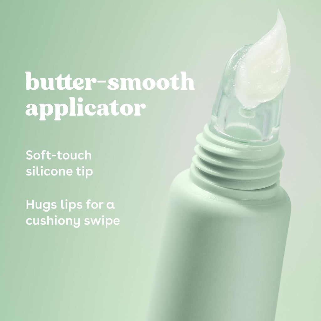 A close-up of a pale mint cosmetic tube with a clear silicone applicator tip holding a dollop of white cream, set against a soft mint green background with white text reading 'butter-smooth applicator' and feature copy.