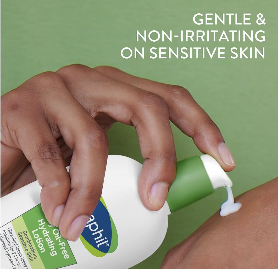 Hand applying a bottle of Cetaphil lotion to skin with a green background