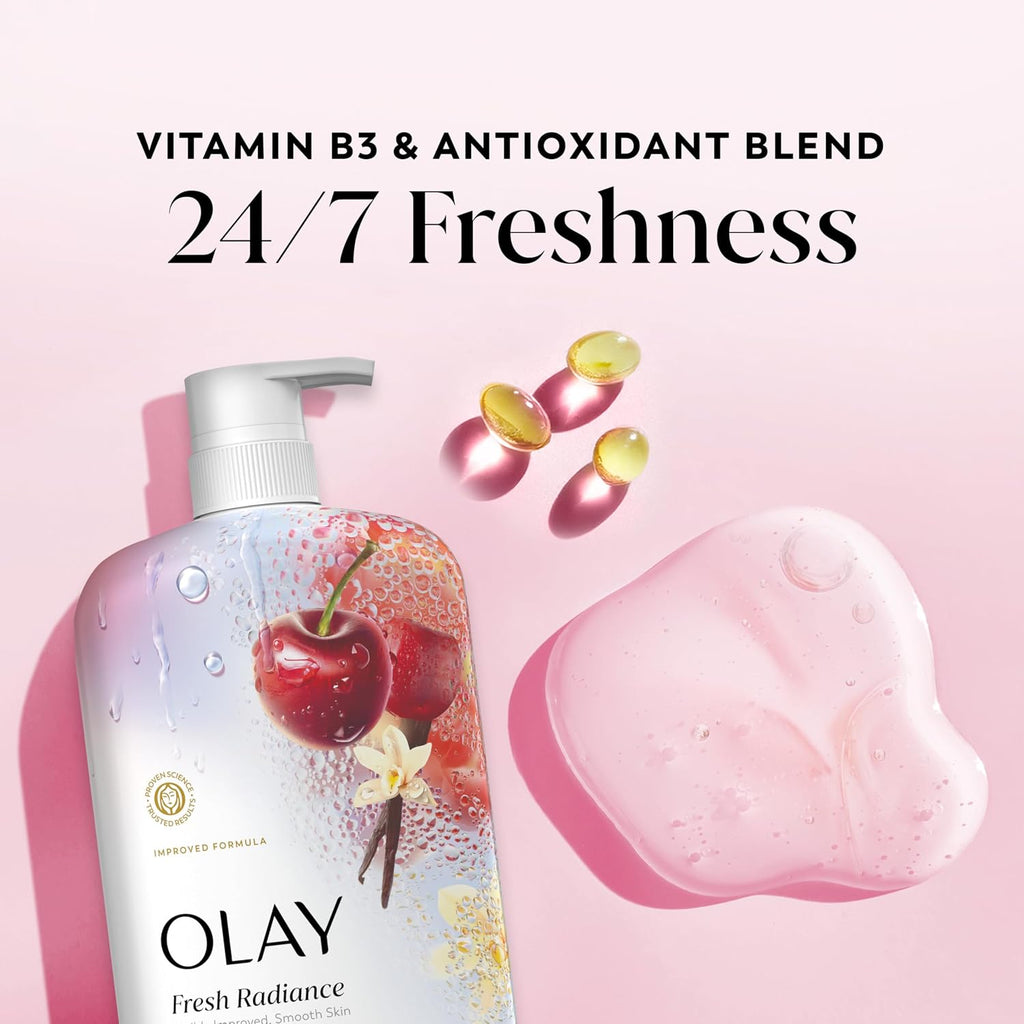 Olay Fresh Radiance Vitamin B3 & Antioxidant Blend pump bottle shown on a soft pink background with decorative cherry artwork, floating pink and yellow capsules, and a translucent pink bar of soap. Large text reads 'VITAMIN B3 & ANTIOXIDANT BLEND 24/7 Freshness'.