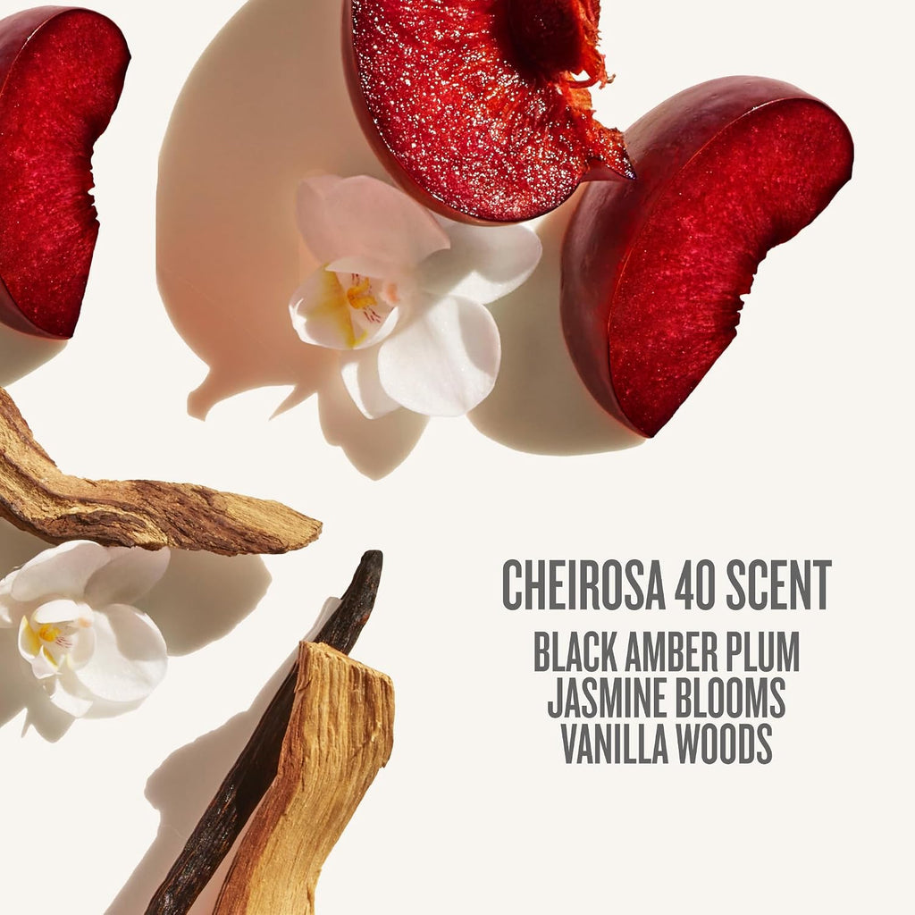 Scented product with plum slices, orchids, and vanilla beans on a light background.