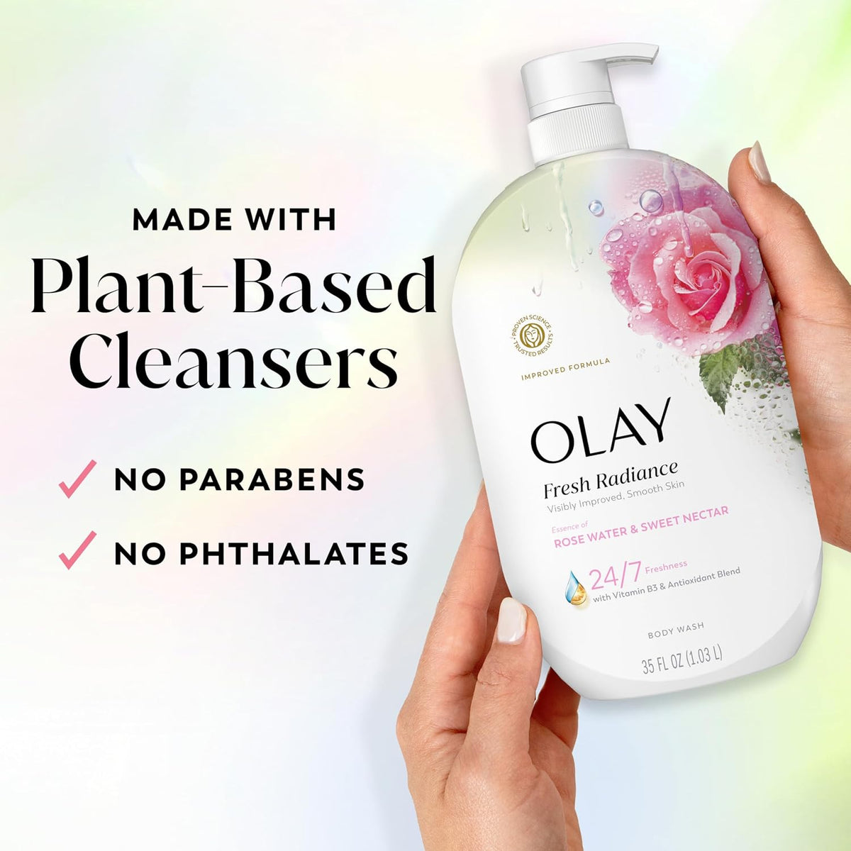 A hand holds a bottle of Olay Fresh Radiance body wash against a soft pastel background with promotional text reading 'Made with Plant-Based Cleansers' and 'No Parabens No Phthalates.'.