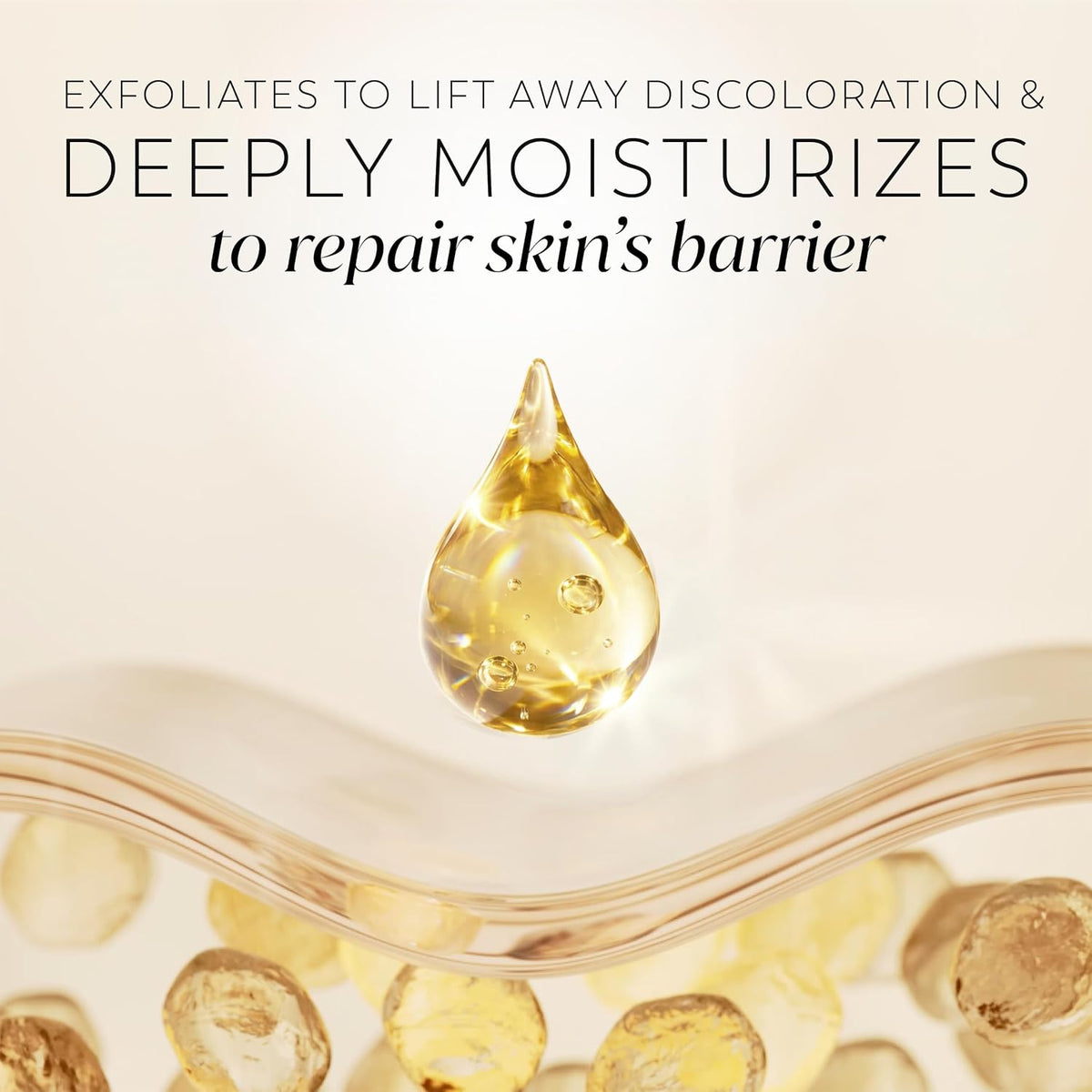 A skincare promotional graphic with text reading 'EXFOLIATES TO LIFT AWAY DISCOLORATION & DEEPLY MOISTURIZES to repair skin's barrier' above a clear teardrop-shaped droplet filled with golden serum, set over a glass bowl containing round golden exfoliating beads.