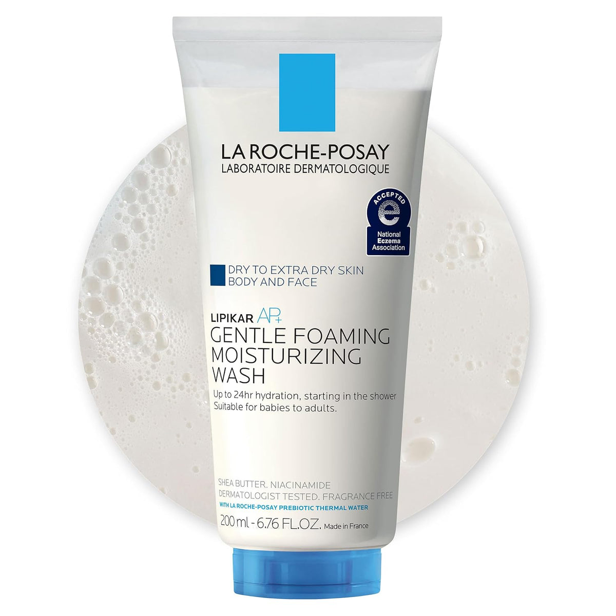 La Roche-Posay Lipikar AP2 Gentle Foaming Moisturizing Wash in a white squeeze tube with a blue cap, shown against a white background with a circular foam graphic behind it.