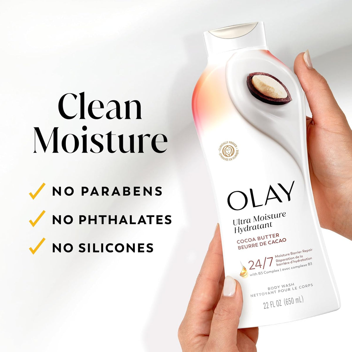 A hand holds an Olay Ultra Moisture Hydratant body wash bottle against a clean white background, with marketing text on the left reading 'Clean Moisture' and bullet points about no parabens, phthalates, and silicones.
