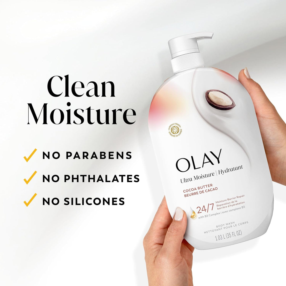 A hand holds an Olay Ultra Moisture body wash bottle against a clean white background, with marketing text on the left reading 'Clean Moisture' and bullet points about no parabens, phthalates, and silicones.