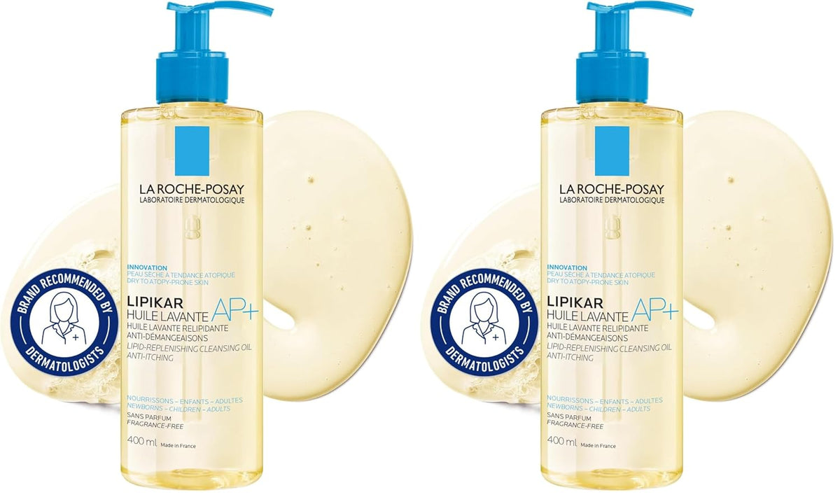 Two bottles of La Roche-Posay Lipikar AP+ cleansing balm with blue pumps, shown side by side with two round beige cleansing sponges behind each bottle on a white background.