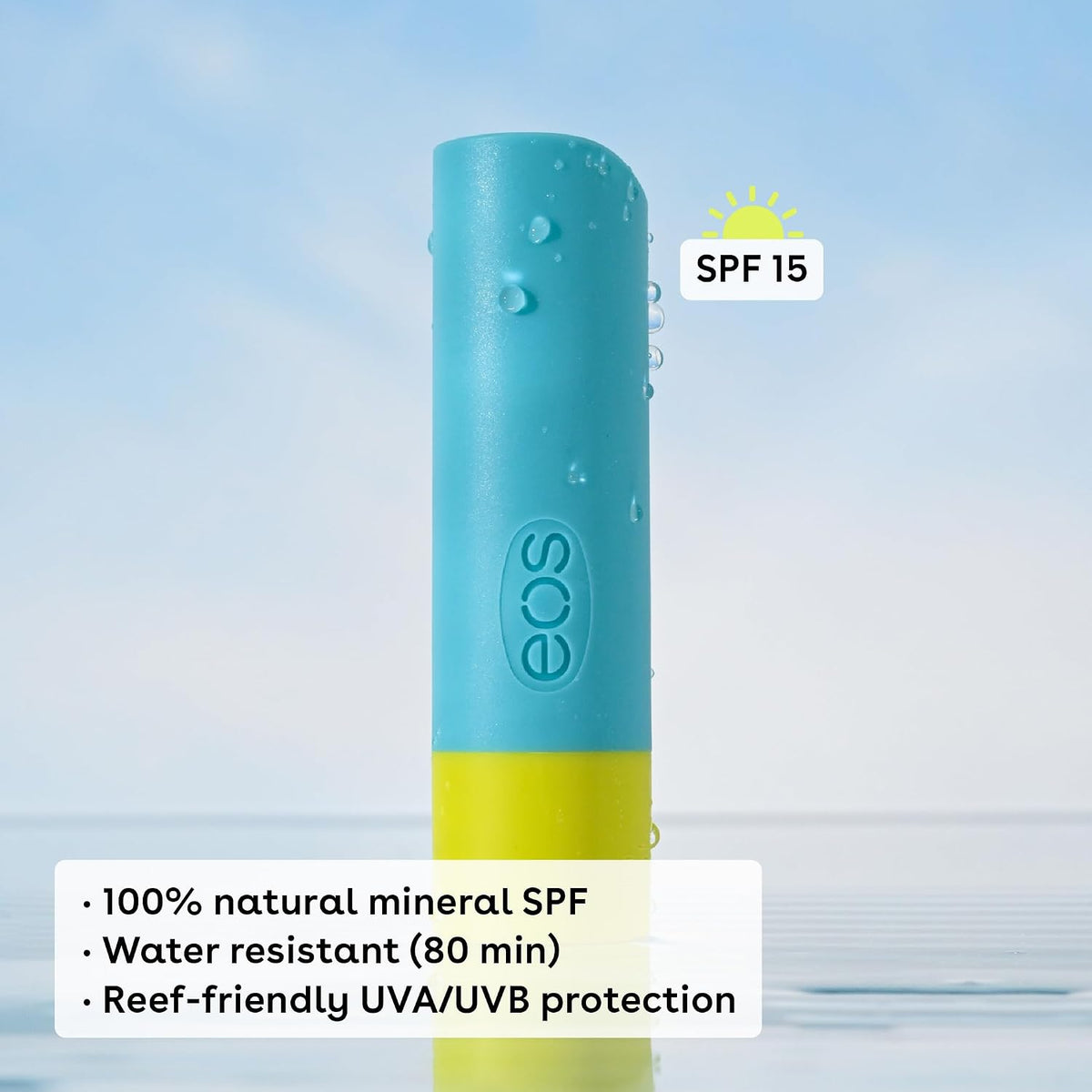 A cylindrical SPF 15 sunscreen stick by EOS, featuring a light blue upper section and a yellow lower section, shown with water droplets on its surface against a light blue water and sky background. Text overlays highlight its water resistance, natural mineral SPF formula, and reef-friendly protection.