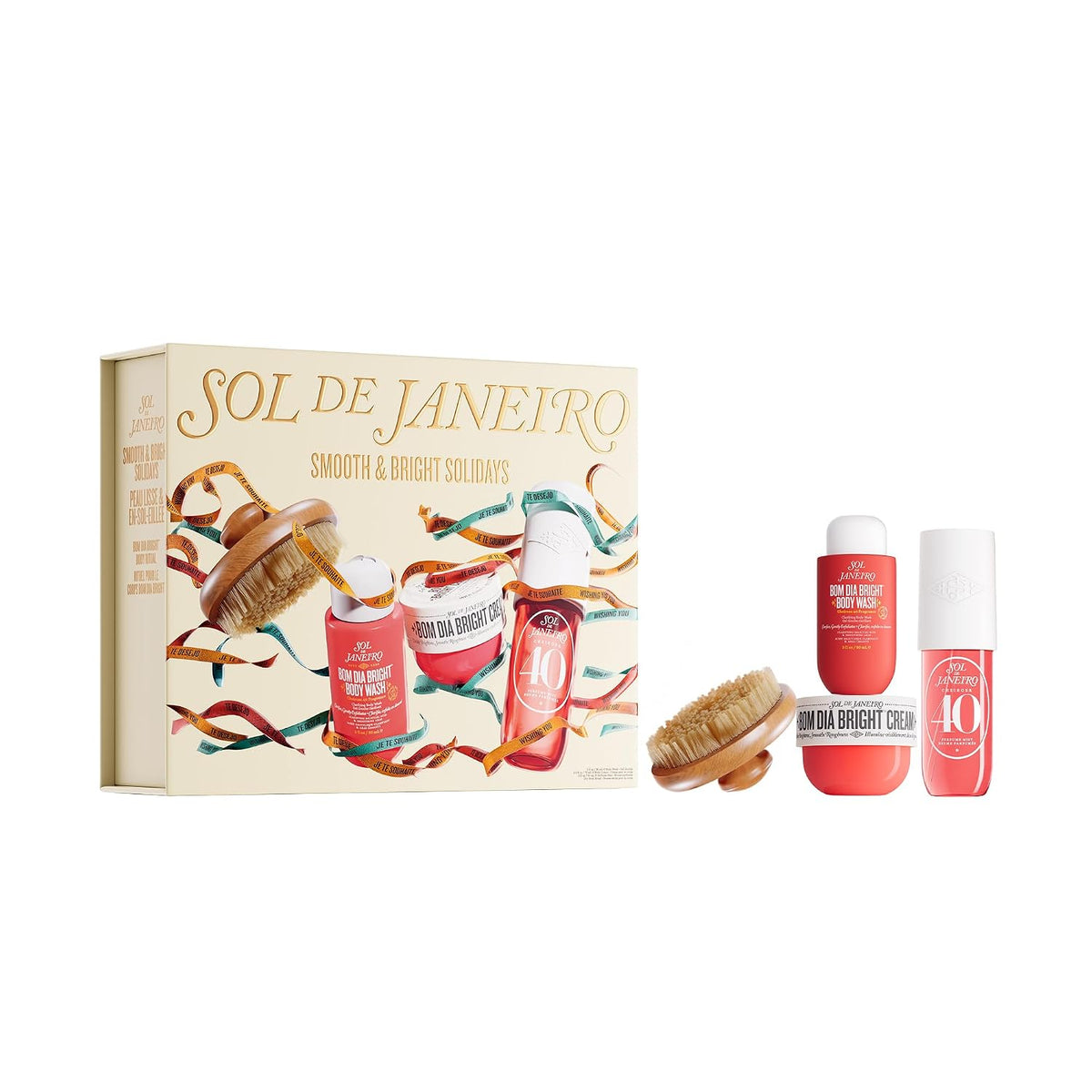 A gift set box held by two hands, featuring the brand name 'SOL DE JANEIRO' and holiday-themed illustrations of body care products and festive ribbons. Text at the top reads 'FEATURING MIDI SIZES OF PERFUME MIST (90 ML) & BODY CREAM (75 ML), PLUS A BODY BRUSH'.