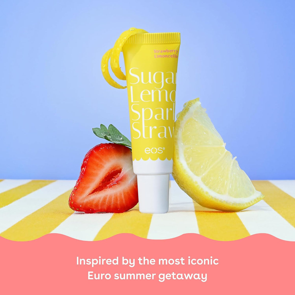 Yellow lip balm tube with strawberry, lemon, and text on a striped surface