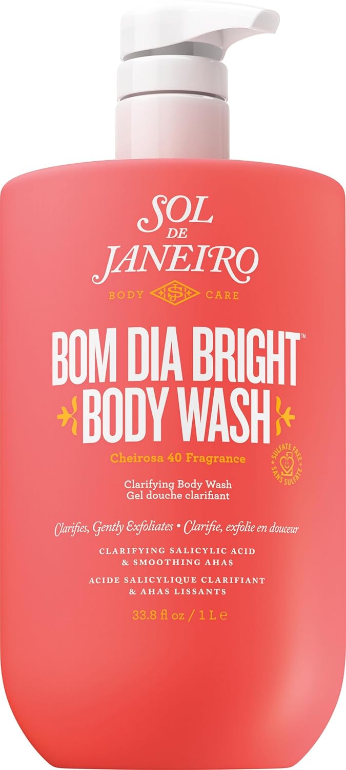 A bottle of Sol de Janeiro Bom Dia Bright Body Wash with a bright coral-pink body, white pump dispenser, and white text on the front label.