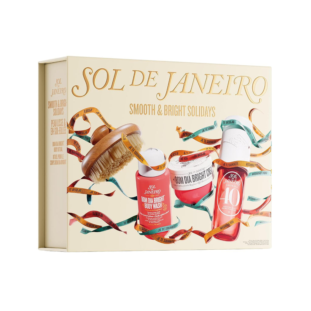 A gift set box held by two hands, featuring the brand name 'SOL DE JANEIRO' and holiday-themed illustrations of body care products and festive ribbons. Text at the top reads 'FEATURING MIDI SIZES OF PERFUME MIST (90 ML) & BODY CREAM (75 ML), PLUS A BODY BRUSH'.