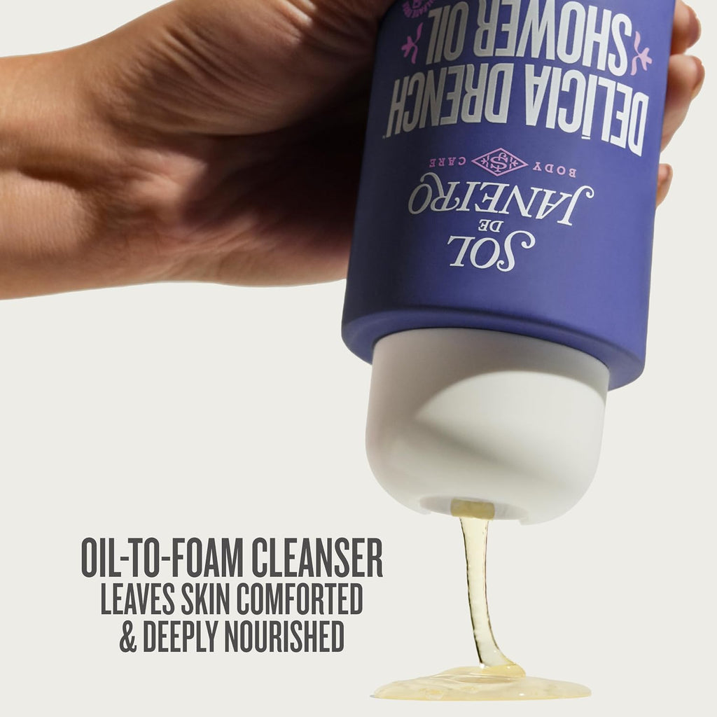 Hand holding a bottle of 'Sole de Shower Oil' with a stream of oil flowing out, on a light gray background.