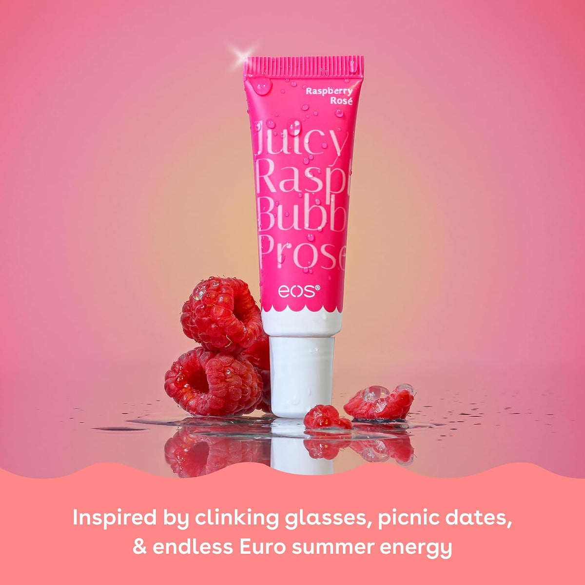 Pink tube of 'Juicy Rasp Bubbl Prose' lip balm with raspberries on a pink background