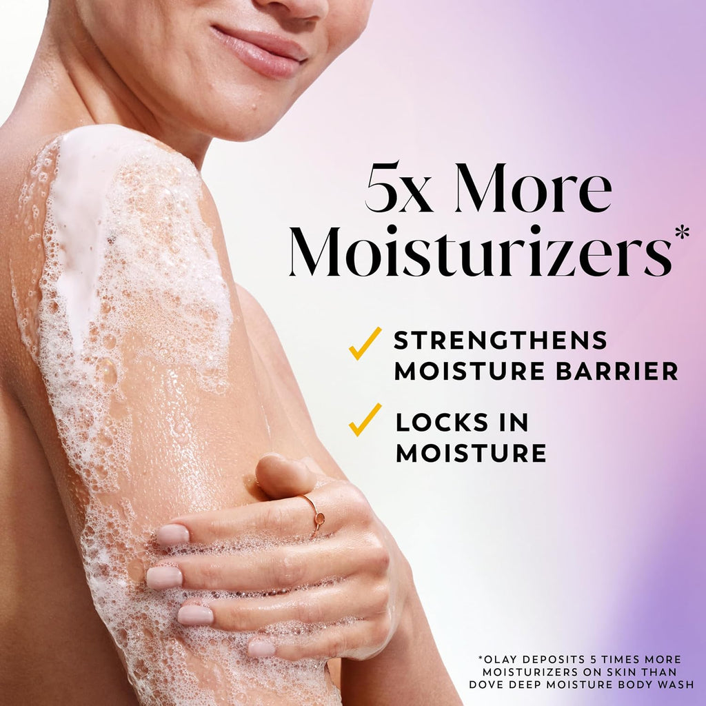 A close-up of a woman's back and shoulder with white body wash foam lathered on the skin, alongside promotional text reading '5x More Moisturizers' and smaller text about strengthening the moisture barrier and locking in moisture.