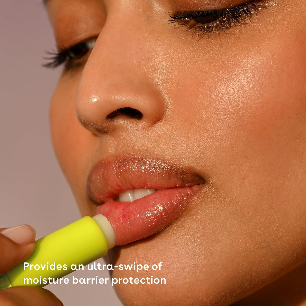 Close-up of a person applying a green lip balm with text about moisture barrier protection.