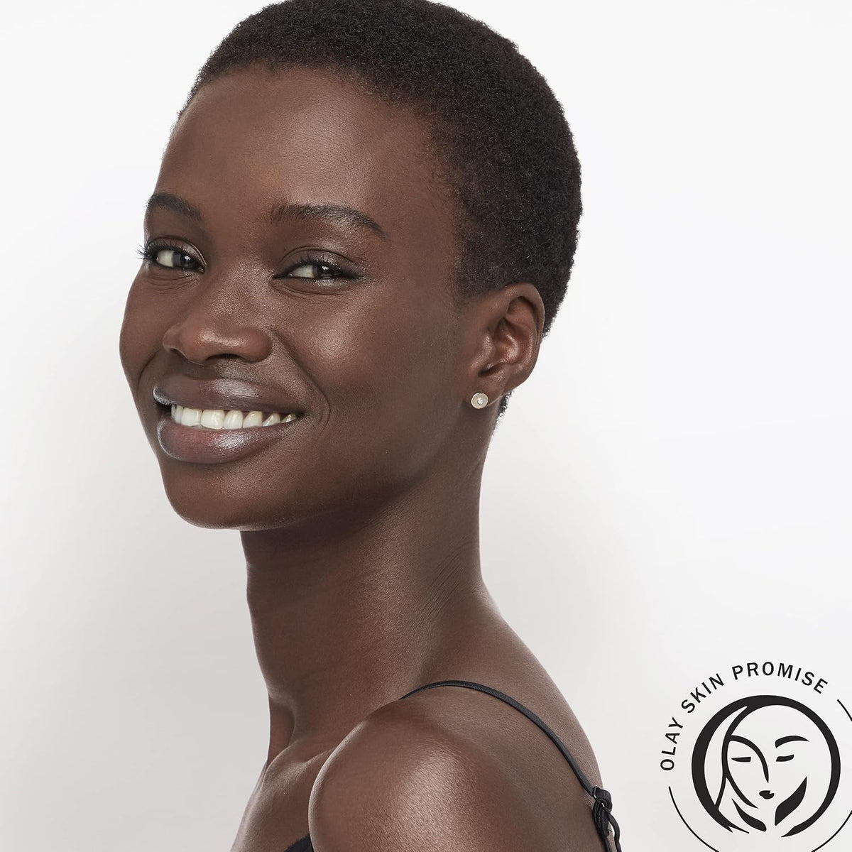 Woman with a short haircut on a white background with Olan Skin Promise logo.