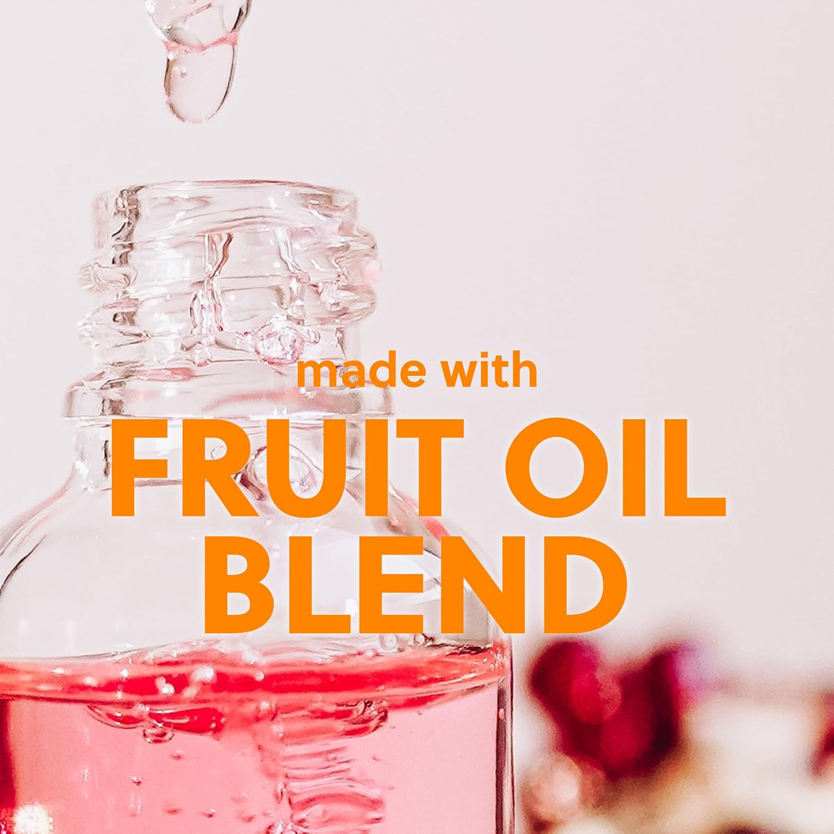 Glass bottle with pink liquid and text 'made with fruit oil blend' on a light background