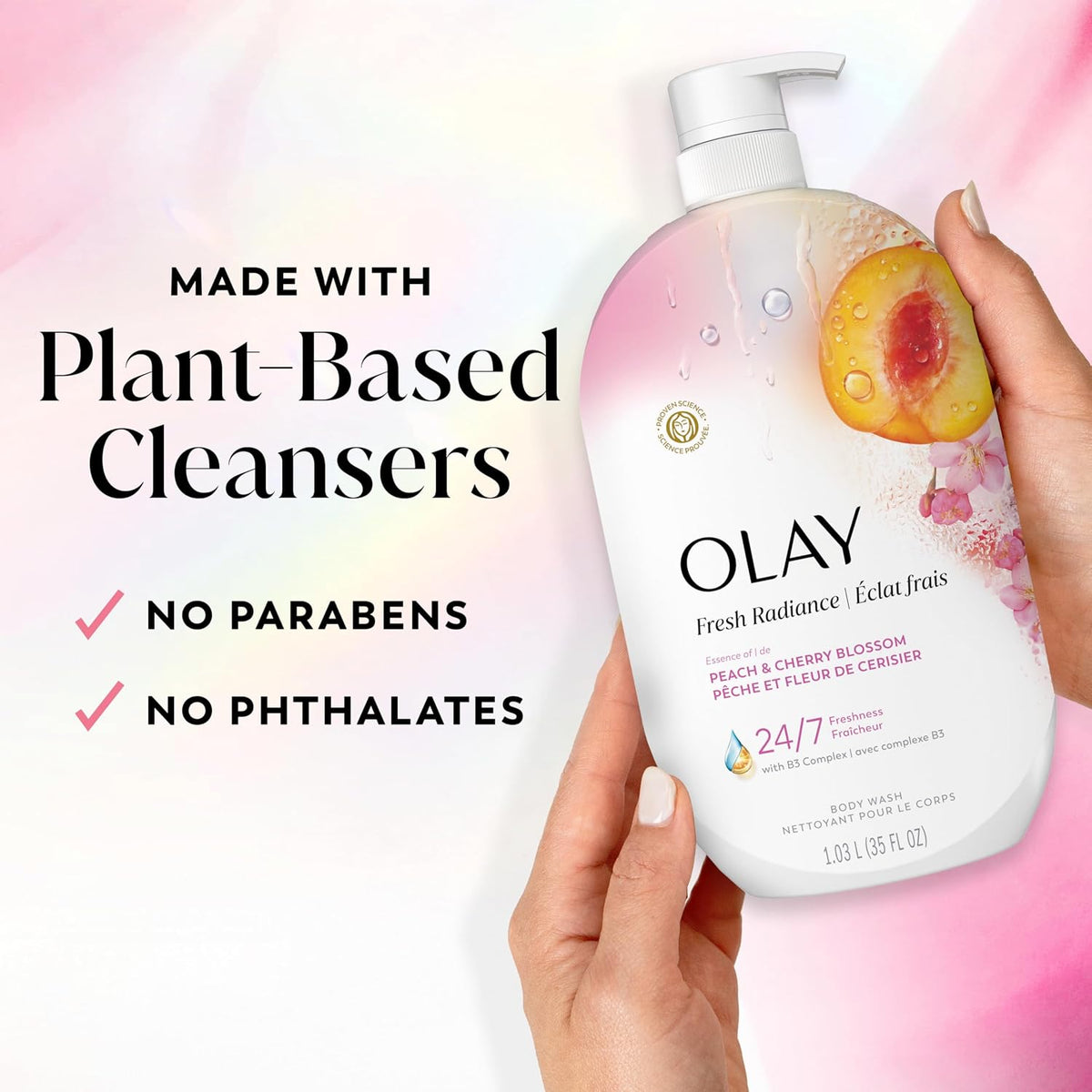 Olay body wash bottle held by a hand with plant-based cleanser information on a colorful background