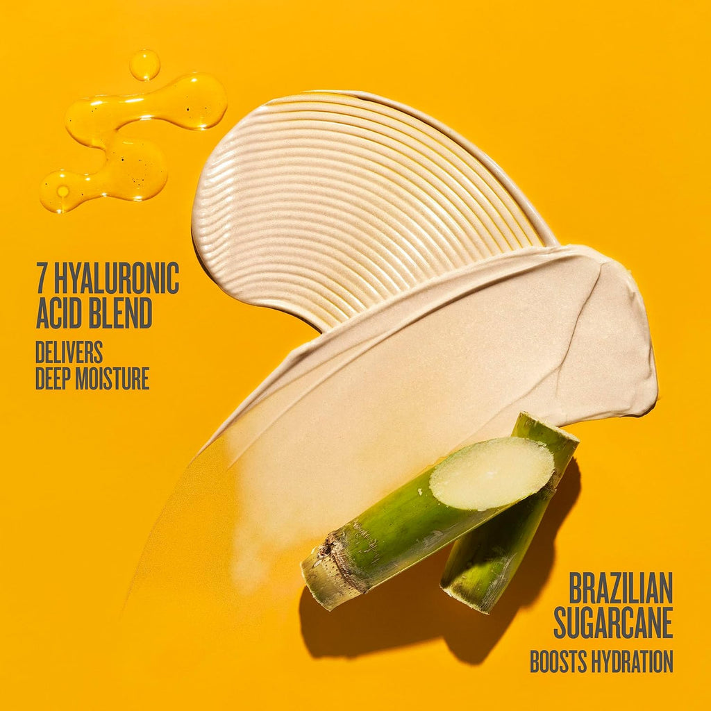 A cosmetic smear of creamy beige product on a bright yellow background, with sliced sugarcane and a glossy droplet graphic. Text reads '7 HYALURONIC ACID BLEND DELIVERS DEEP MOISTURE' and 'BRAZILIAN SUGARCANE BOOSTS HYDRATION'.