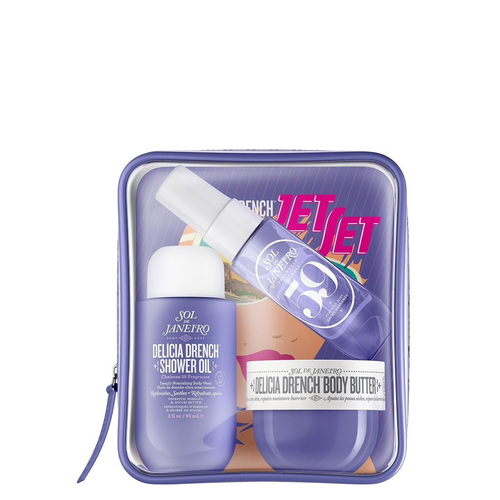 A Sol de Janeiro travel set in a clear zippered case, featuring a purple shower oil bottle, a body butter jar, and a travel-sized shower spray, on a white background.