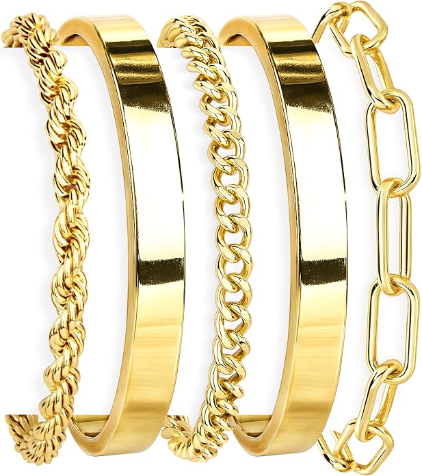 Set of four gold bangles with different designs on a white background