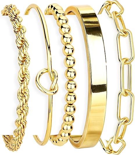 Set of gold bangles with different designs on a white background