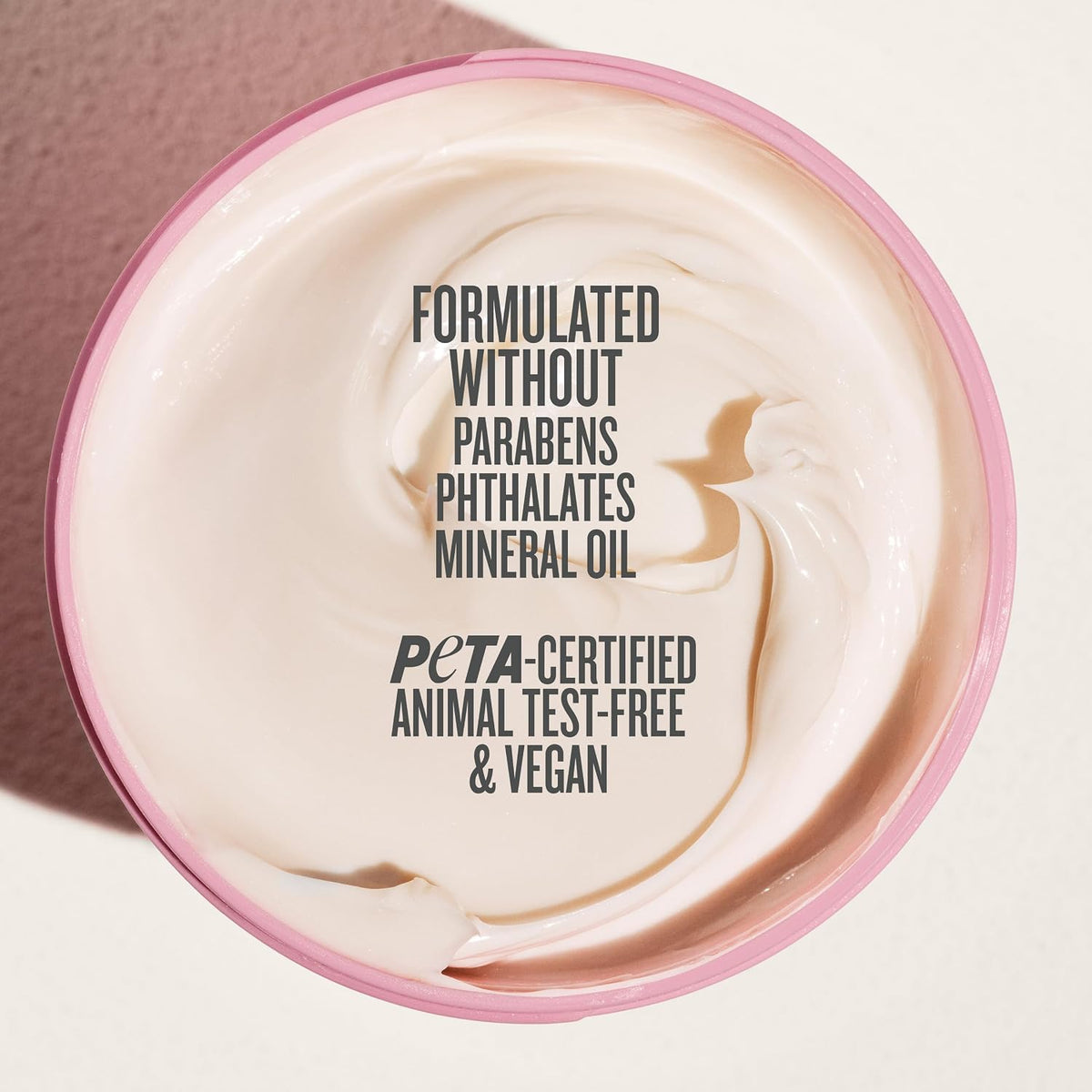 Jar of cream with text indicating ingredients and certifications on a light background